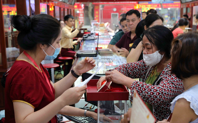 Khách hàng giao dịch vàng miếng. (Ảnh: TTXVN) Giá vàng trong nước mất mốc 57 triệu đồng, tỷ giá trung tâm đi lên ảnh 1