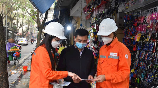 Nhân viên EVNHANOI hướng dẫn người dân ứng dụng công nghệ để theo dõi việc sử dụng điện. (Ảnh: evnhanoi) Doanh nghiệp, người dân vẫn ‘thấp thỏm’ trước việc cắt điện luân phiên ảnh 3