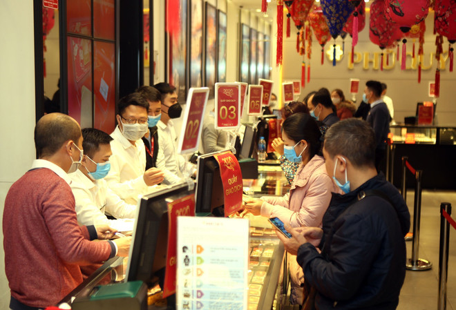 Khách hàng giao dịch vàng miếng. (Ảnh: TTXVN) Ngược chiều thế giới, giá vàng SJC trong nước đi lên ngày cận Tết ảnh 1