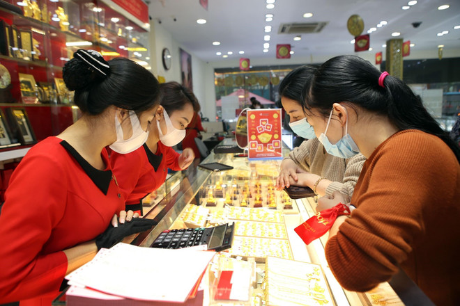 Khách hàng giao dịch vàng miếng. (Ảnh: TTXVN) Giá vàng SJC giảm rất mạnh, lùi về mốc 64 triệu đồng mỗi lượng ảnh 1