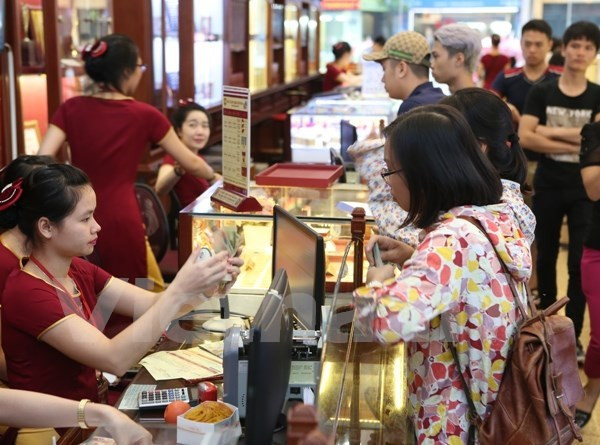 Khách hàng giao dịch vàng miếng. (Ảnh: Đức Duy/Vietnam+) Giảm phiên sáng cuối tuần, giá vàng SJC lùi về ngưỡng 69,6 triệu đồng ảnh 1