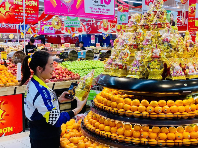 Các chương trình khuyến mại, giảm giá góp phần bình ổn thị trường. (Ảnh: Đức Duy/Vietnam+) 3-mot-khach-hang-hao-hung-vi-cho-n-mua-uoc-hop-q-ua-tet-ung-y-8699.jpg