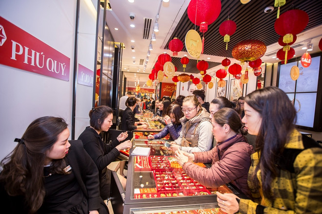 Khách hàng giao dịch vàng miếng. (Ảnh: Đức Duy/Vietnam+) Dù giảm nhẹ, giá vàng SJC vẫn cao hơn thế giới 300.000 đồng mỗi lượng ảnh 1