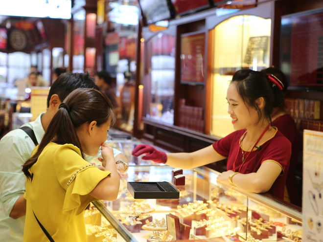 Khách hàng đang giao dịch vàng miếng. (Ảnh: Đức Duy/Vietnam+) Đầu tuần, hai thương hiệu vàng miếng trong nước cùng giảm sâu ảnh 1