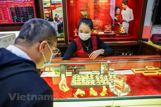Khách hàng giao dịch vàng tại thị trường Hà Nội. (Ảnh: PV/Vietnam+) Hai thương hiệu vàng miếng cùng đi lên, tỷ giá trung tâm cộng 2 đồng ảnh 1