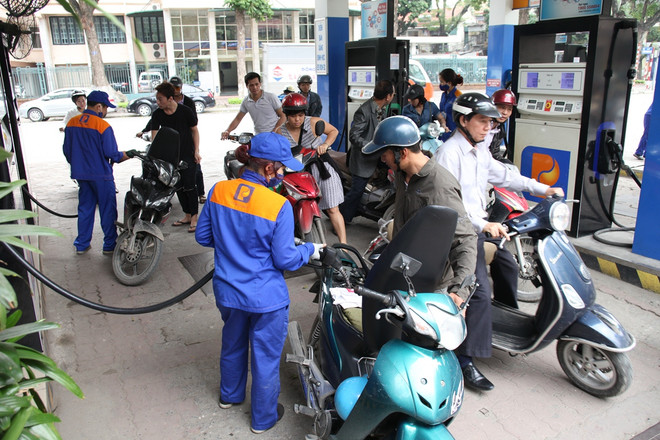 Nhân viên Petrolimex đang bán xăng cho khách hàng. (Ảnh: Đức Duy/Vietnam+) Từ 15 giờ, giá xăng Ron95-III giảm hơn 200 đồng mỗi lít ảnh 1