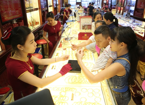 Khách hàng đang giao dịch vàng miếng. (Ảnh: Đức Duy/Vietnam+) Giảm giá nhưng thương hiệu SJC vẫn cao hơn thế giới 5,1 triệu đồng ảnh 1