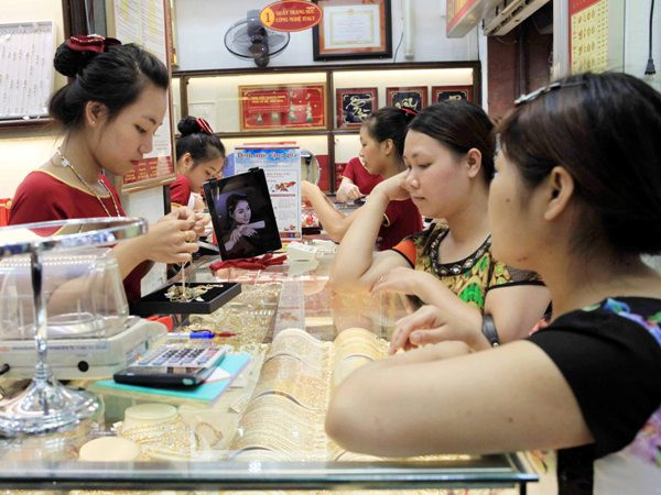 Khách hàng giao dịch vàng miếng. (Ảnh: TTXVN) Giá vàng Rồng Thăng Long cao hơn thương hiệu SJC 150.000 đồng ảnh 1