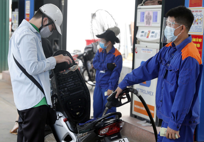 Nhân viên Petrolimex bán xăng cho khách hàng. (Ảnh: TTXVN) Bộ Công Thương: Không để thiếu hụt nguồn cung xăng dầu mọi tình huống ảnh 1