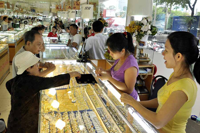 Khách hàng đang giao dịch vàng. (Ảnh: TTXVN) Giá SJC giảm hơn 100.000 đồng mỗi lượng sau tuần giao dịch ảm đạm ảnh 1