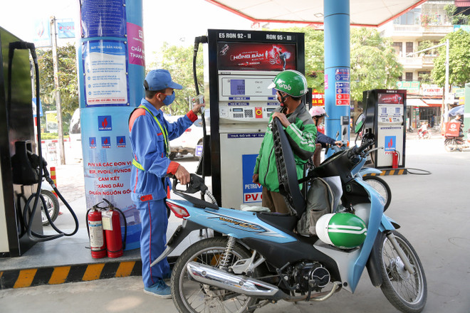 Nhân viên xăng dầu thực hiện các biện pháp phòng chống COVID-19 khi giao dịch với khách hàng. (Ảnh: Đức Duy/Vietnam+) Giữ ổn định giá xăng, dầu trong nước sau khi tăng chi quỹ bình ổn ảnh 1