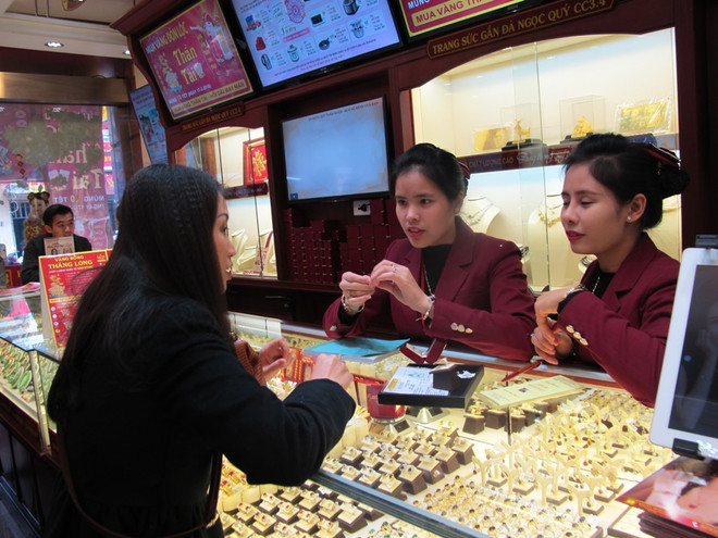 Khách hàng đang giao dịch vàng miếng. (Ảnh: PV/Vietnam+) Giá vàng đồng loạt giảm sâu, tỷ giá trung tâm vượt ngưỡng 22.130 đồng ảnh 1
