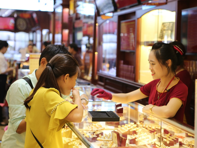 Khách hàng đang giao dịch vàng miếng. (Ảnh: PV/Vietnam+) Vàng SJC cao hơn thương hiệu Rồng Thăng Long gần 1,5 triệu đồng ảnh 1