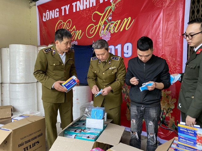 Lực lượng Quản lý thị trường kiểm tra sản phẩm khẩu trang tại Công ty Trách nhiệm hữu hạn Việt Hàn. (Ảnh: PV/Vietnam+) Phát hiện xưởng sản xuất khẩu trang giả làm từ giấy vệ sinh ảnh 1