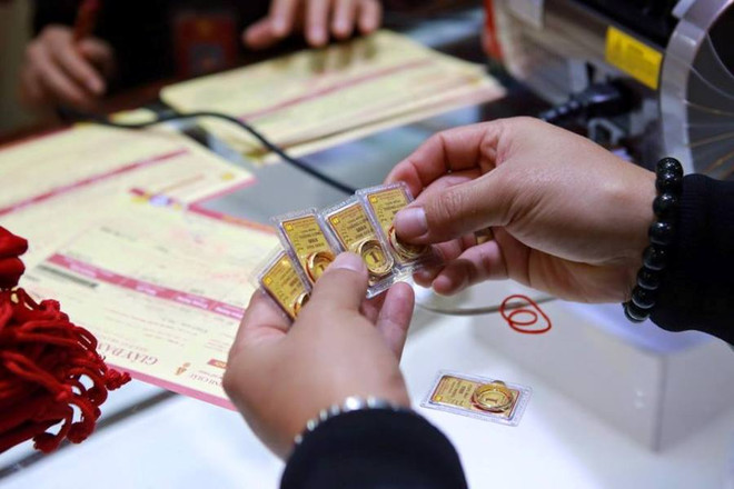 Kiểm tra chất lượng vàng miếng trước khi giao dịch. (Ảnh: Đức Duy/Vietnam+) Thương hiệu SJC đồng loạt tăng, chênh lệch với thế giới nới rộng ảnh 1