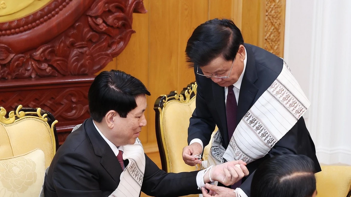 Tổng Bí thư, Chủ tịch nước Lào Thongloun Sisoulith buộc chỉ cho Chủ tịch nước Lương Cường. (Ảnh: Lâm Khánh/TTXVN)