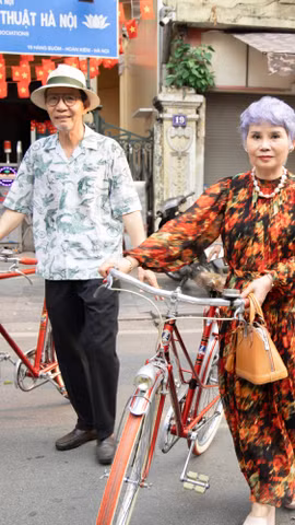 Kỷ lục gia Đào Xuân Tình và vợ bên những chiếc xe đạp cổ. (Ảnh: PV/Vietnam+)