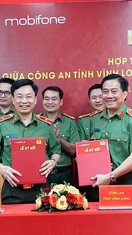 Thiếu tướng Trương Sơn Lâm - Chủ tịch MobiFone và Thiếu tướng Nguyễn Thanh Hải - Giám đốc Công an tỉnh Vĩnh Long trao văn bản hợp tác. (Ảnh: PV/Vietnam+)