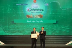 Thứ trưởng Thường trực Bộ Y tế trao giấy chứng nhận và tặng hoa cho Cơ sở y tế đạt giải Nhất. (Ảnh: PV/Vietnam+)