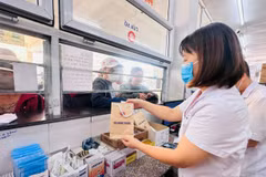 Nhân viên y tế cấp phát thuốc bảo hiểm y tế cho người bệnh. (Ảnh: T.G/Vietnam+)