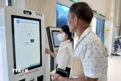 Hướng dẫn người dân đăng ký khám, chữa bệnh và thanh toán viện phí qua căn cước công dân gắn chíp. (Ảnh: Mỹ Hà/TTXVN)