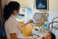 Bác sỹ siêu âm, kiểm tra cho bệnh nhân. (Ảnh: PV/Vietnam+)