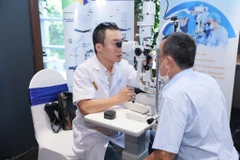 Bác sỹ kiểm tra mắt cho người cao tuổi tại buổi lễ phát động. (Ảnh: PV/Vietnam+)