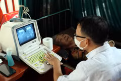 Bác sỹ siêu âm cho người dân trong một chương trình khám sàng lọc miễn phí. (Ảnh: TTXVN/Vietnam+)