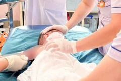 Nhân viên y tế theo dõi tình trạng cho trẻ. (Ảnh: PV/Vietnam+)