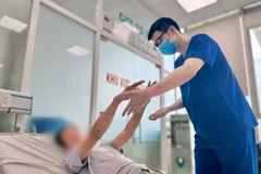 Bác sỹ Bệnh viện Bệnh Nhiệt đới Trung ương theo dõi sức khỏe cho bệnh nhân. (Ảnh: PV/Vietnam+)