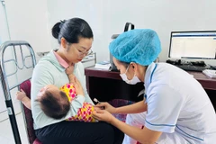 Nhân viên y tế tiêm chủng cho trẻ nhỏ tại tỉnh Quảng Trị. (Ảnh: T.G/Vietnam+)