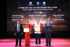Ban Tổ chức trao chứng nhận và hoa cho các tác giả đoạt giải. (Ảnh: PV/Vietnam+)