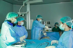 Phó giáo sư Nguyễn Lê Bảo Tiến thực hiện ca phẫu thuật cột sống. (Ảnh: PV/Vietnam+)