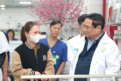 Thủ tướng Chính phủ Phạm Minh Chính thăm hỏi bệnh nhân và người nhà bệnh nhân. (Ảnh: PV/Vietnam+)