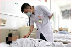 Bác sỹ theo dõi tình trạng cho bệnh nhân. (Ảnh: PV/Vietnam+)