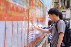 Người dân nghiên cứu danh sách các ứng cử viên được niêm yết tại các điểm bầu cử. (Ảnh: Khoa Chương/TTXVN)