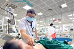 Bác sỹ Bệnh viện Bệnh Nhiệt đới Trung ương theo dõi sức khỏe cho một bệnh nhân mắc cúm B trong tình trạng nặng. (Ảnh: PV/Vietnam+)