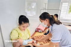 Nhân viên y tế theo dõi sức khỏe cho trẻ em tại Trạm y tế. (Ảnh: T.G/Vietnam+)