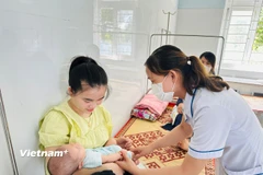 Nhân viên y tế theo dõi sức khỏe cho trẻ em tại Trạm y tế. (Ảnh: T.G/Vietnam+)