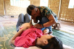 Cô đỡ Lò Thị Đường ở bản Nậm Đích, xã Chà Nưa (Nậm Pồ, Điện Biên) đến nhà thăm khám cho sản phụ. (Ảnh: Phan Quân/TTXVN)