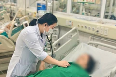 Bác sỹ theo dõi tình trạng cho bệnh nhân. (Ảnh: PV/Vietnam+)