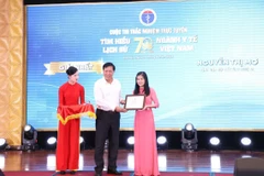 Thứ trưởng Bộ Y tế Đỗ Xuân Tuyên trao giải cho người đoạt giải Nhất. (Ảnh: PV/Vietnam+)