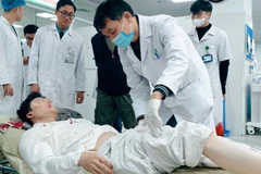 Các bác sỹ Bệnh viện Hữu nghị Việt Đức kiểm tra tình trạng cho các bệnh nhân. (Ảnh: PV/Vietnam+)