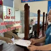 Người dân làm thủ tục hành chính tại bộ phận một cửa xã Phúc Thịnh, huyện Ngọc Lặc phấn khởi nhận kết quả. (Ảnh: TTXVN phát)