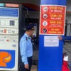Lực lượng quản lý thị trường thành phố Đà Nẵng triển khai dán thông báo số điện thoại đường dây nóng, tại các cửa hàng xăng, dầu. (Ảnh: Trần Tĩnh/TTXVN)