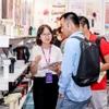Khách tham quan nghe tư vấn về sản phẩm thiết bị gia dụng. (Ảnh: CTV/Vietnam+)