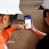 Công nhân (EVNHANOI) hướng dẫn khách hàng sử dụng Ứng dụng EVNHANOI trên website evnhanoi.vn. (Ảnh: Quốc Lũy/TTXVN)