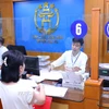 Người dân giải quyết thủ tục hành chính tại Trung tâm Phục vụ hành chính công Thành phố Hà Nội. (Ảnh: Văn Điệp/TTXVN)