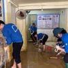 Thanh niên tình nguyện trường Đại học Điện lực dọn dẹp bùn đất sau bão lũ cho người dân. (Ảnh: Trường Đại học Điện lực)