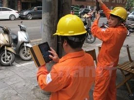 Nhân viên EVN đang chốt chỉ số công tơ cho khách hàng. (Ảnh: Đức Duy/Vietnam+)